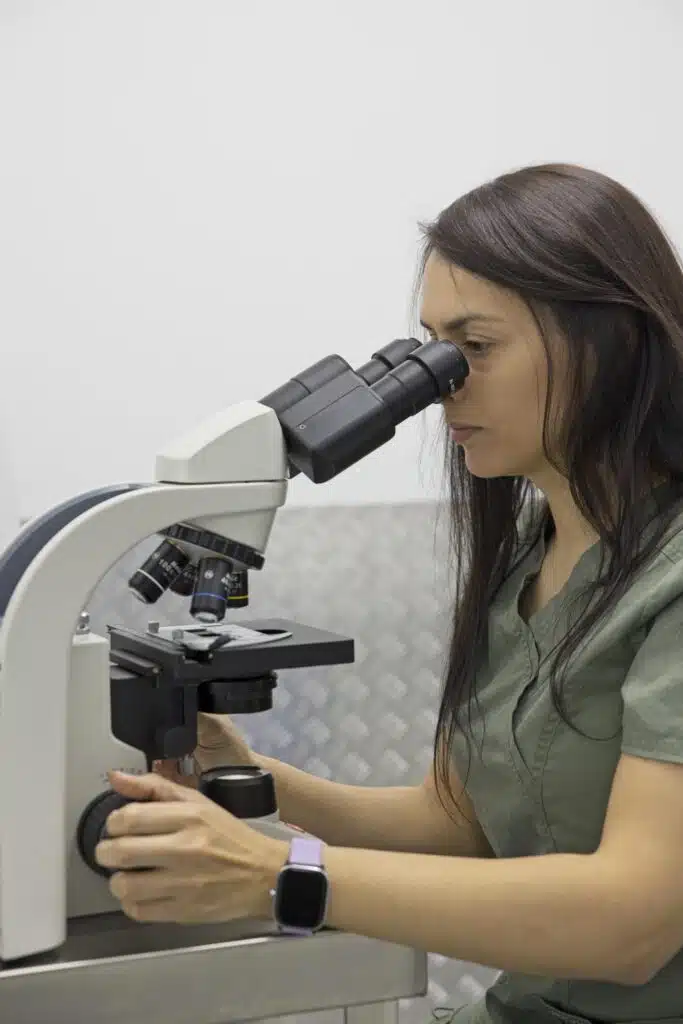 La veterinaria mira una muestra al microscopio en el laboratorio de la clínica